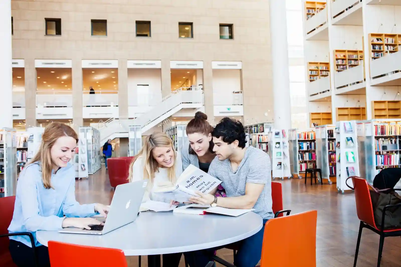 Students collaborating on a tech project with a tablet.